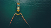 Aerial view: Ocean cleaning ships deploy nets to collect floating plastic waste. 